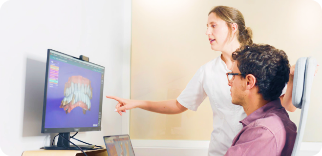 Woman showing another woman a program on the computer.